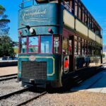 Experience the vintage charm of the Franschhoek double-decker tram under a clear blue sky.